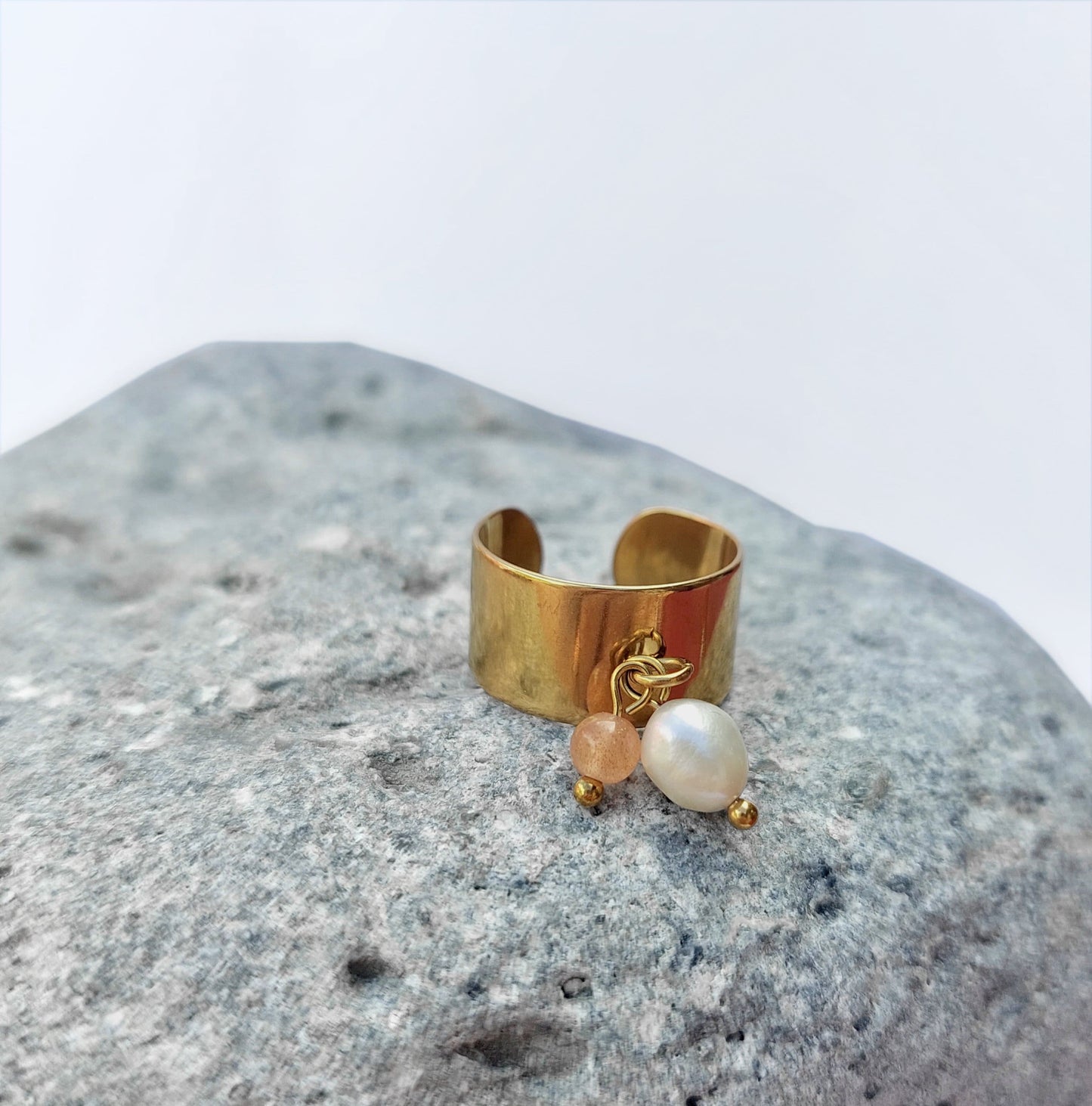 Bague en acier inoxydable à breloques de pierre de soleil et de perle d'eau douce.