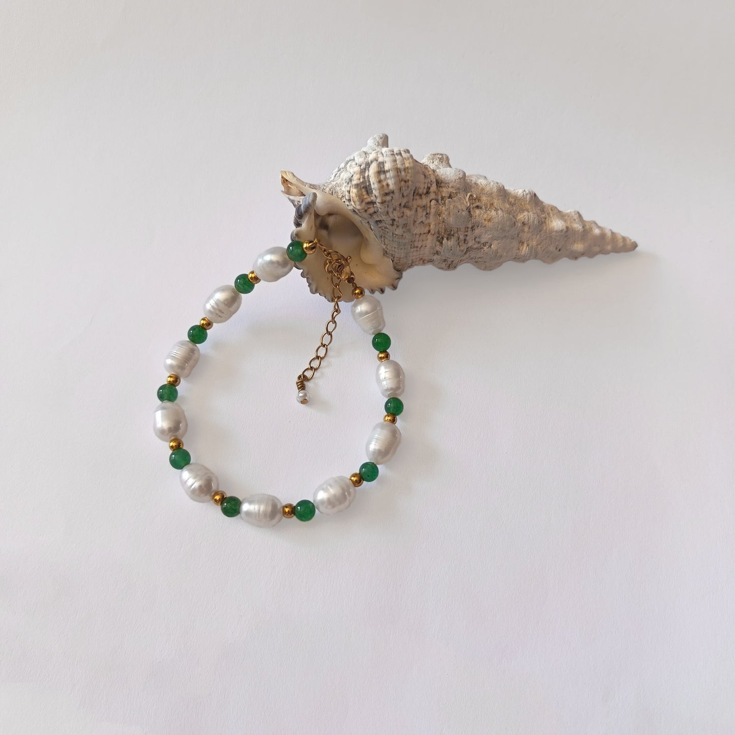 Bracelet en acier inoxydable pour femme avec pierres de couleur vertes et perles d'eau douce.