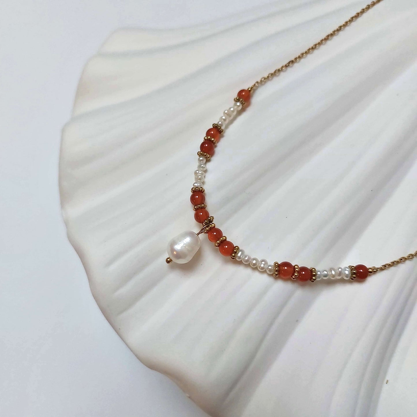 Collier en acier inoxydable à pendentif avec perles d'eau douce et pierres de cornaline rouge.