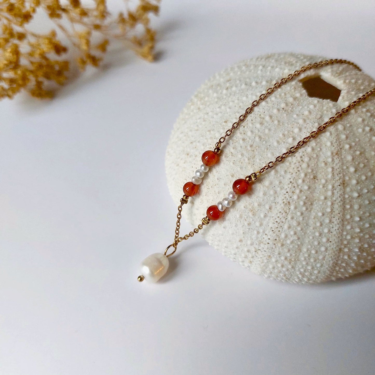 Collier élégant avec chaine en acier inoxydable paré de perles d'eau douce et perles de Cornaline rouge.