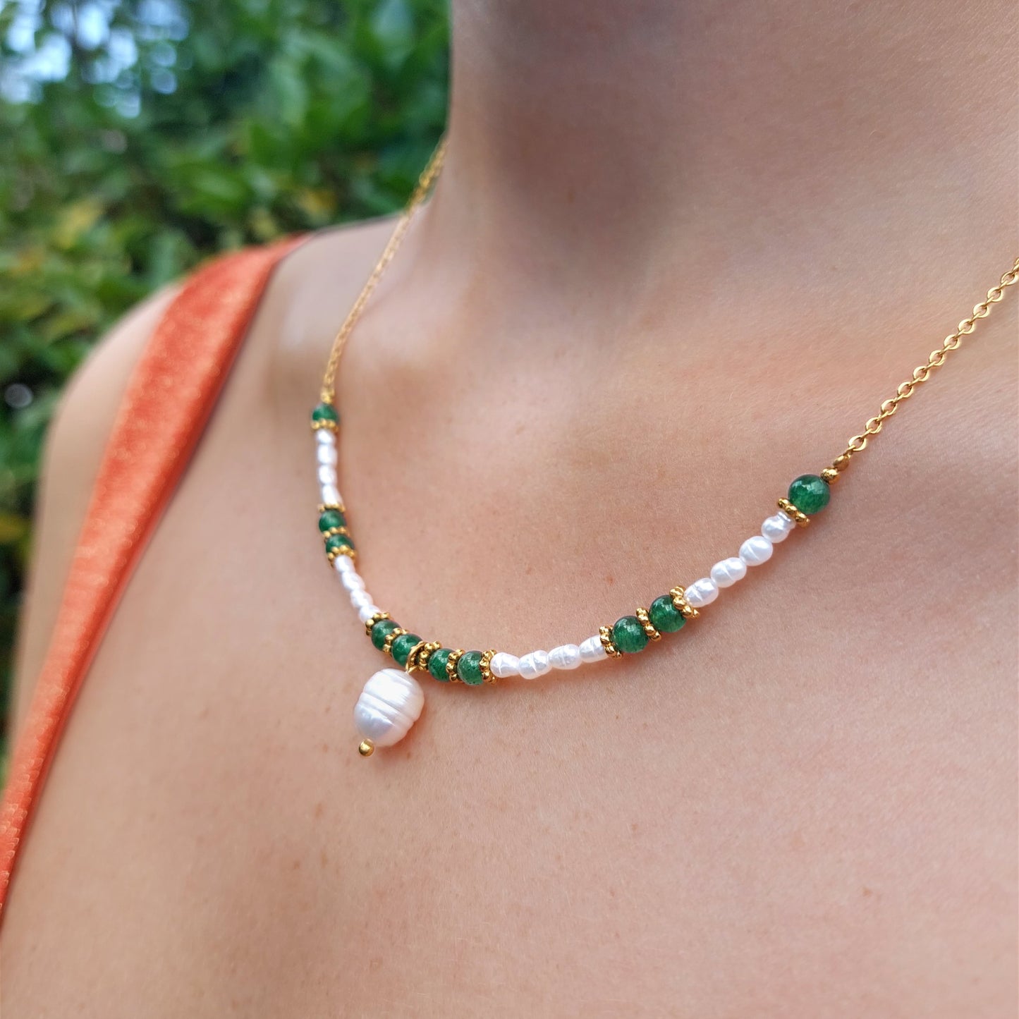 Collier en acier inoxydable, perles d'eau douce et pierres vertes naturelles porté par une femme.