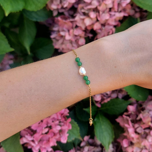 Bracelet en acier inoxydable avec perle d'eau douce et perles de couleur vertes porté par une femme.