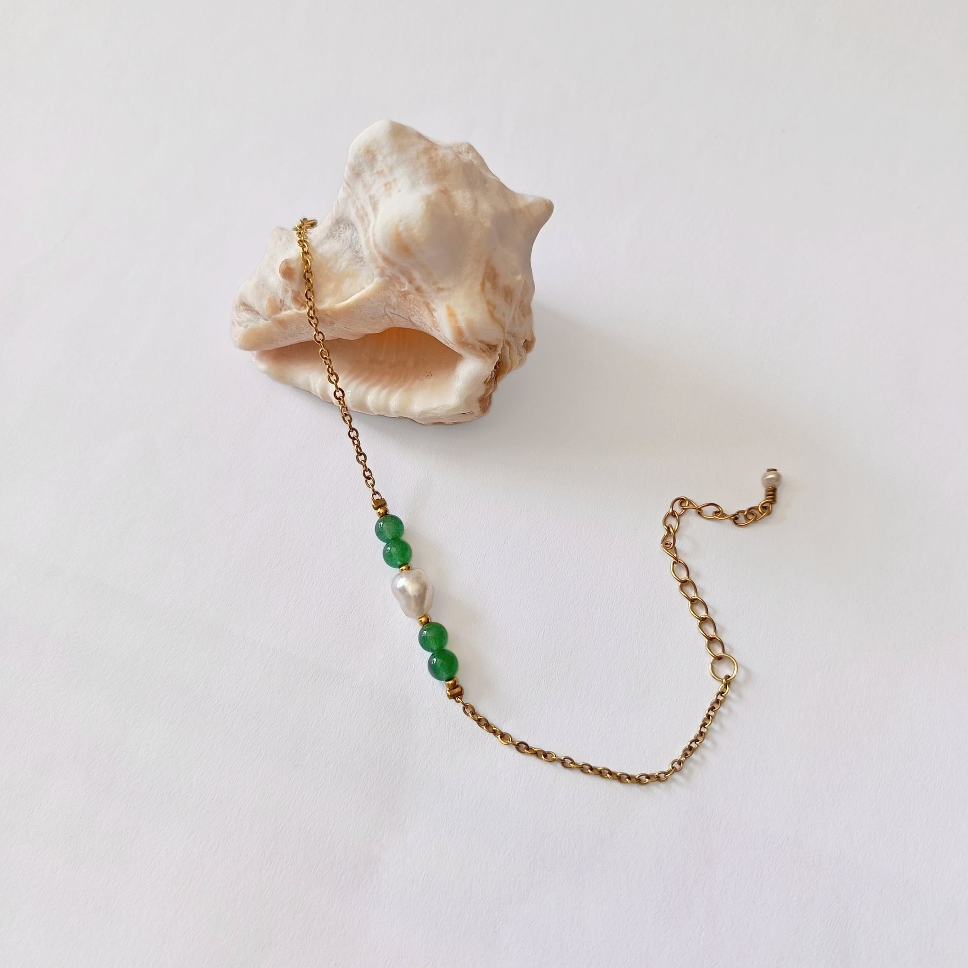 Bracelet élégant Acropora en perle d'eau douce et perles d'aventurine verte  posé sur fond blanc.