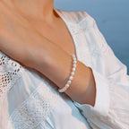 Bracelet porté orné de perles d'eau douce naturelles blanches irrégulières.