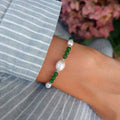 Bracelet en acier inoxydable argenté, perles d'eau douce et pierre d'aventurine vertes foncées porté par une femme.