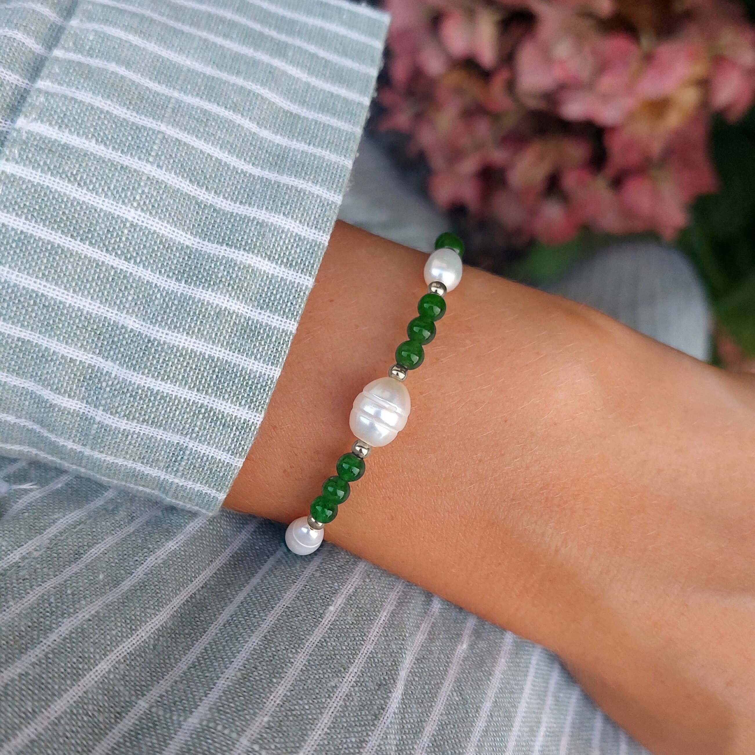 Bracelet en acier inoxydable argenté, perles d'eau douce et pierre d'aventurine vertes foncées porté par une femme.