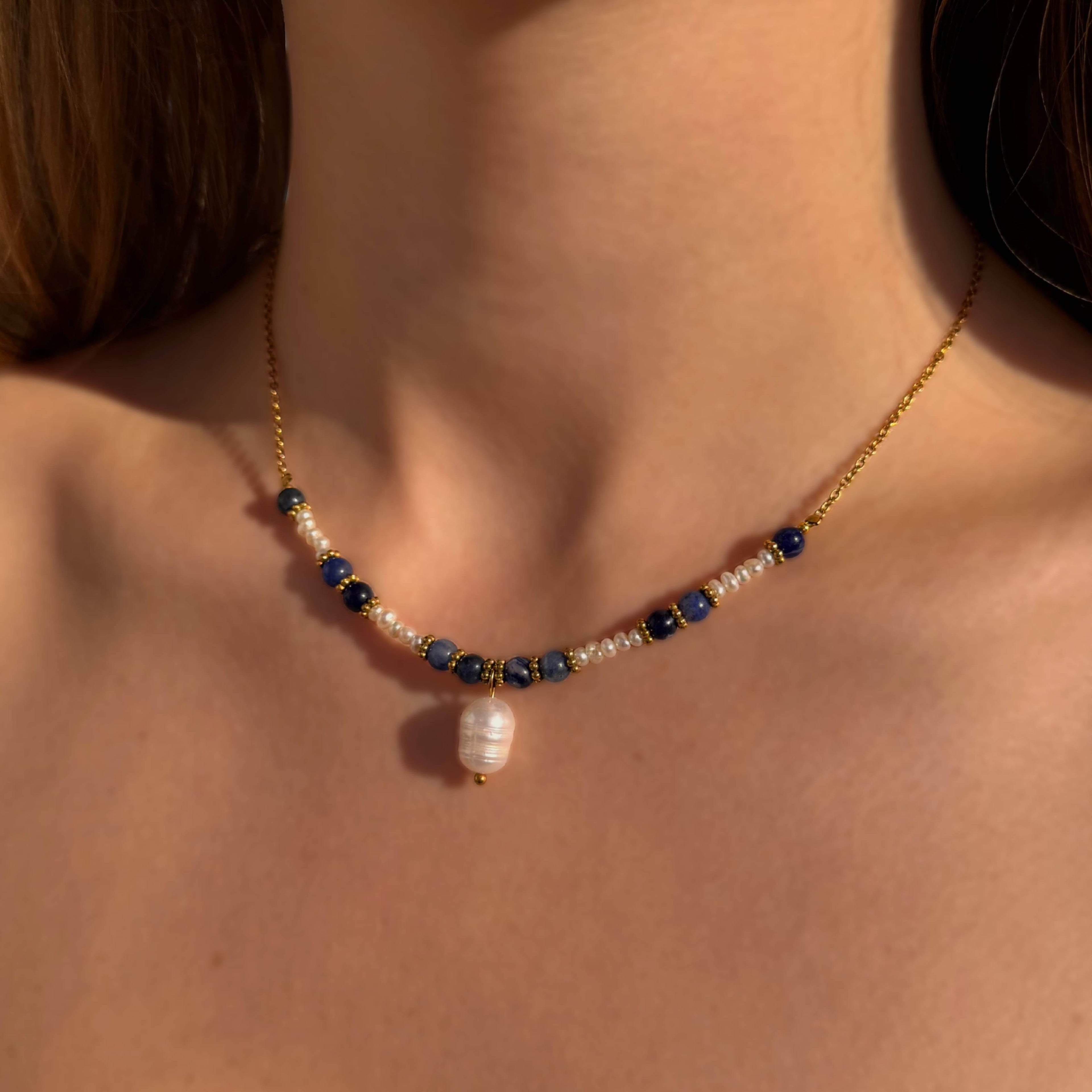 collier pour femme en acier inoxydable et perles naturelles porté à la plage par une femme