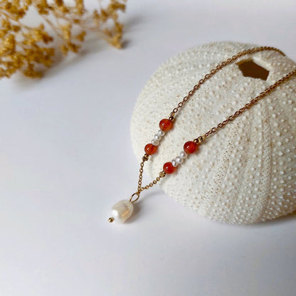 Collier élégant avec chaine en acier inoxydable paré de perles d'eau douce et perles de Cornaline rouge.