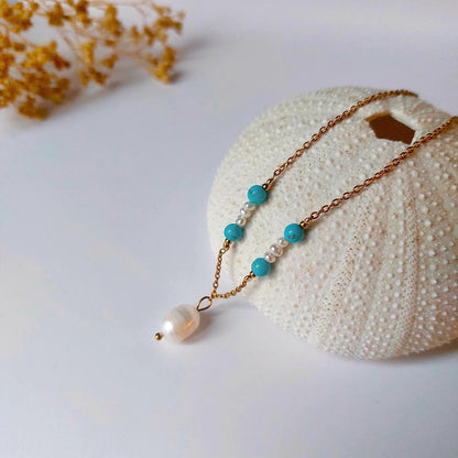 Collier élégant avec chaine en acier inoxydable paré de perles d'eau douce et perles de Turquoise bleue.