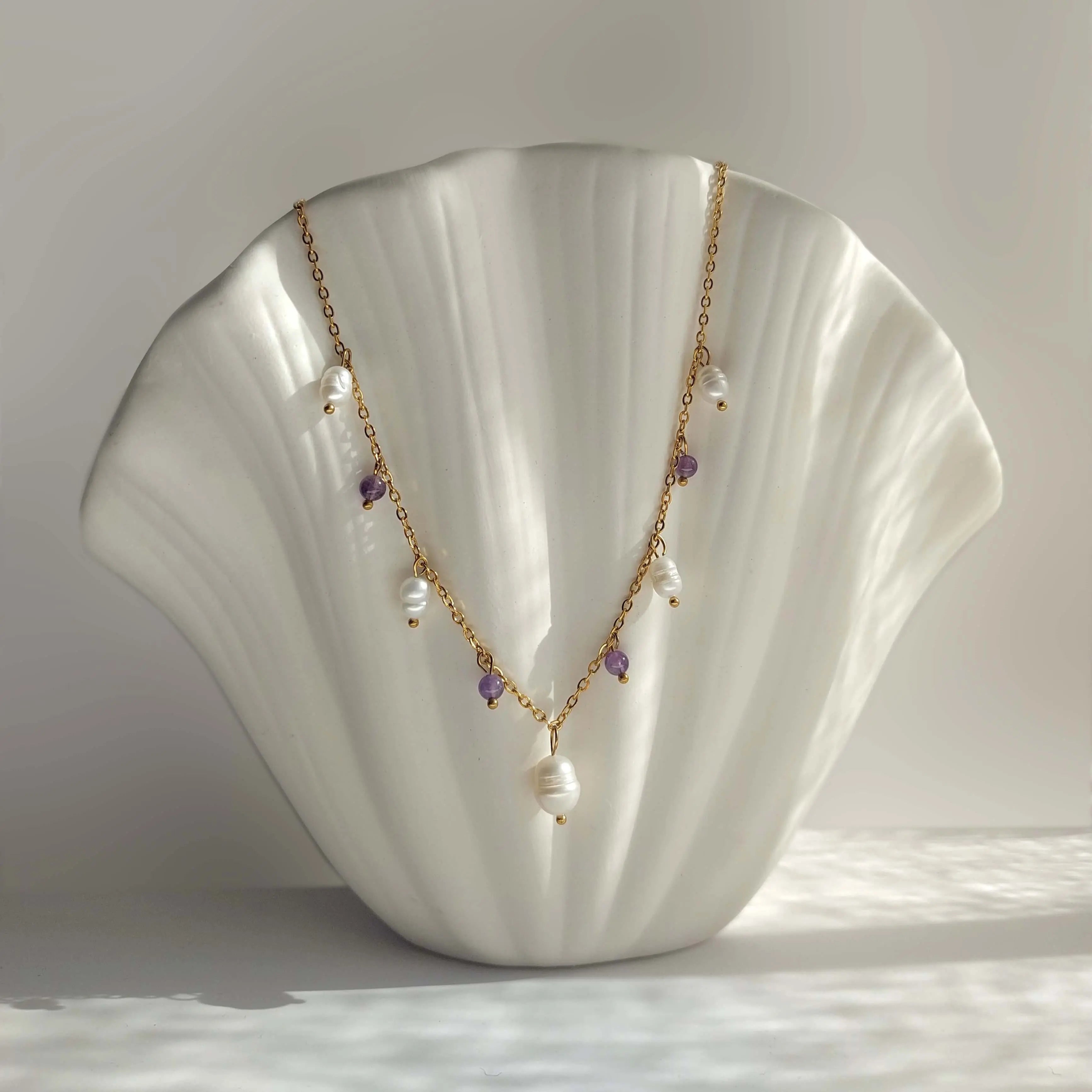 Collier Meandrina en perles d'eau douce et perles d'améthyste violette posé sur fond blanc