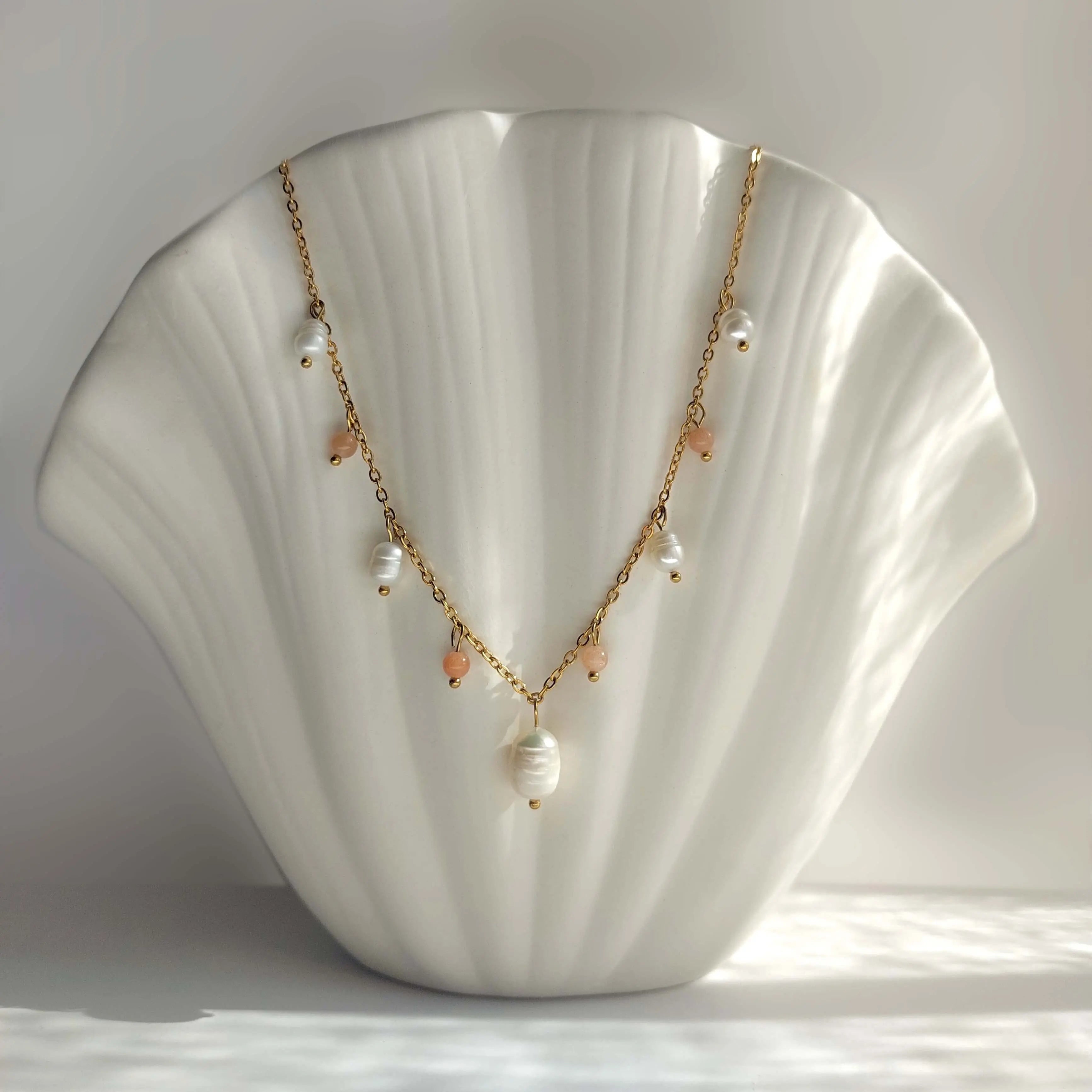 Collier Meandrina en perles d'eau douce et perles de pierre de soleil posé sur fond blanc