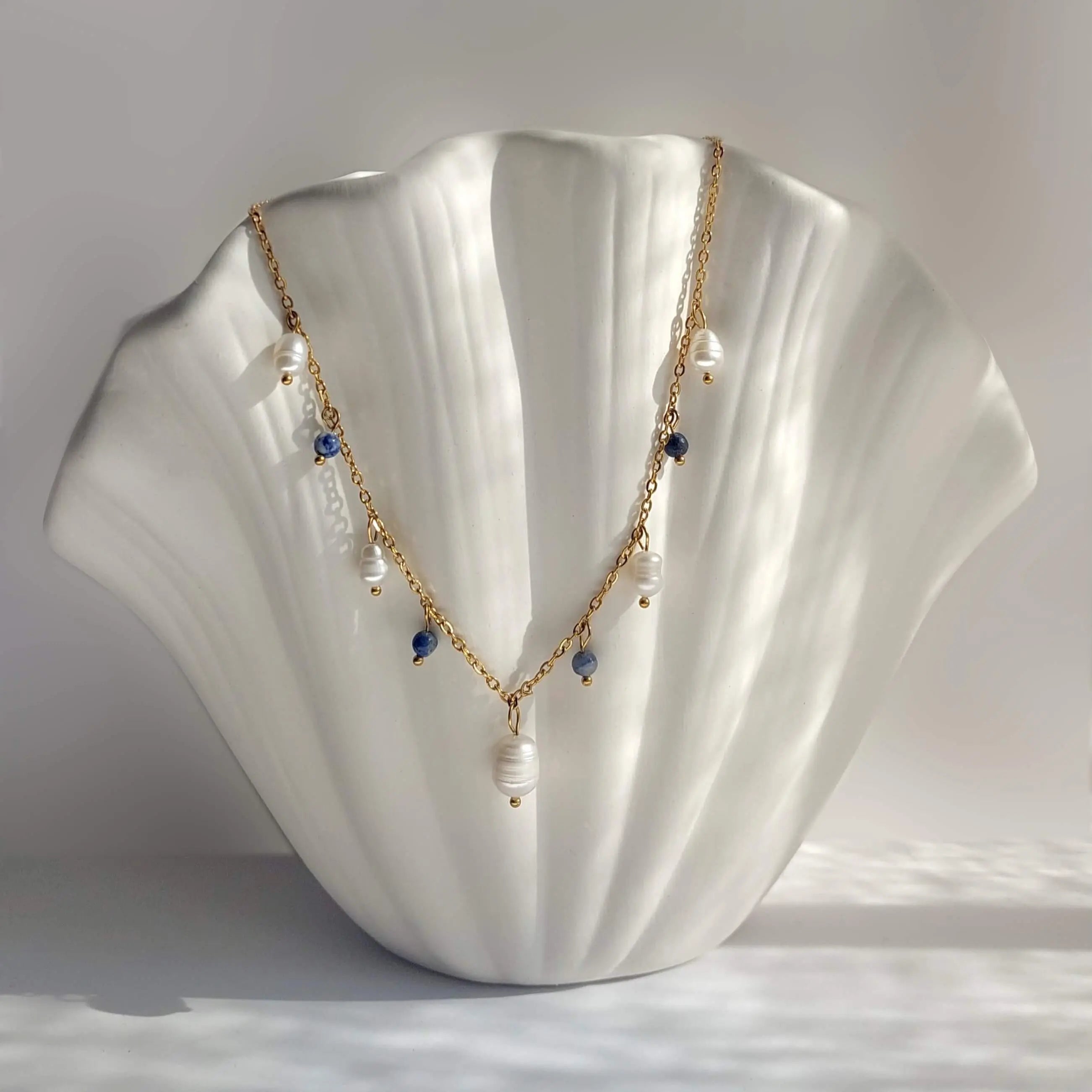 Collier Meandrina en perles d'eau douce et perles de sodalite bleue posé sur fond blanc