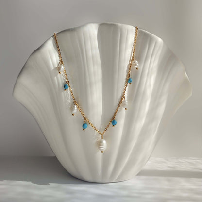 Collier Meandrina en perles d'eau douce et perles de turquoise posé sur fond blanc