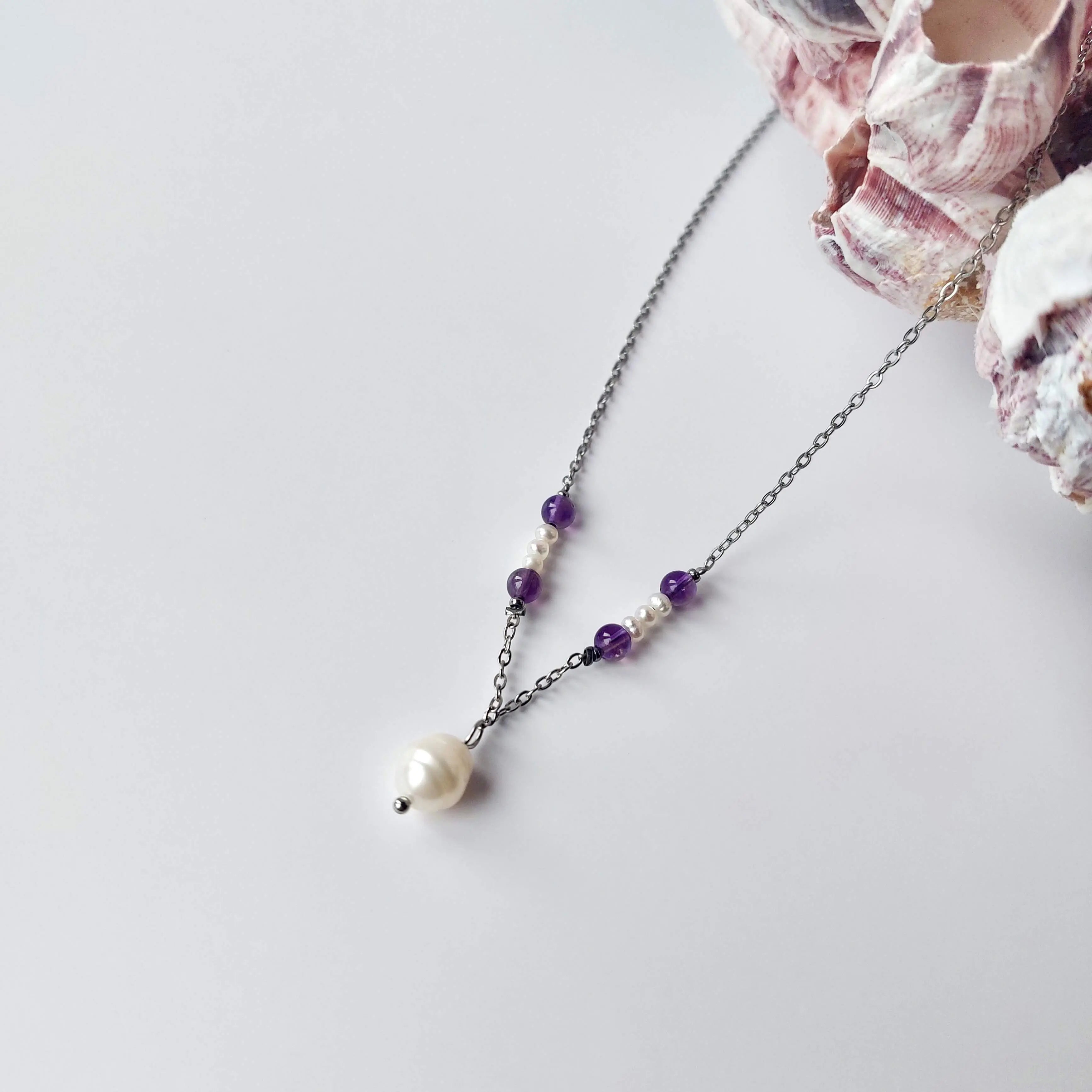 Collier élégant avec chaine en acier inoxydable argenté paré de perles d'eau douce et perles d'améthyste violette.