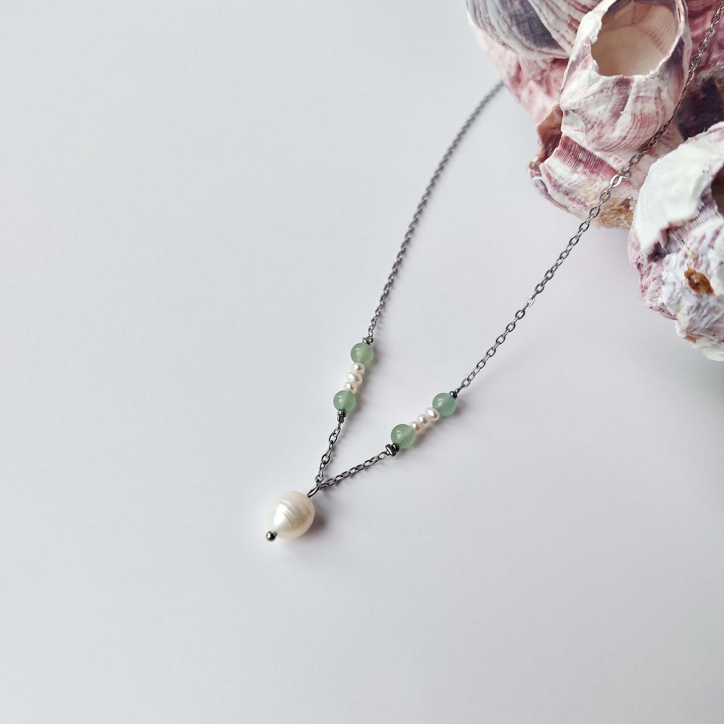 Collier élégant avec chaine en acier inoxydable argenté paré de perles d'eau douce et perles d'aventurine verte.
