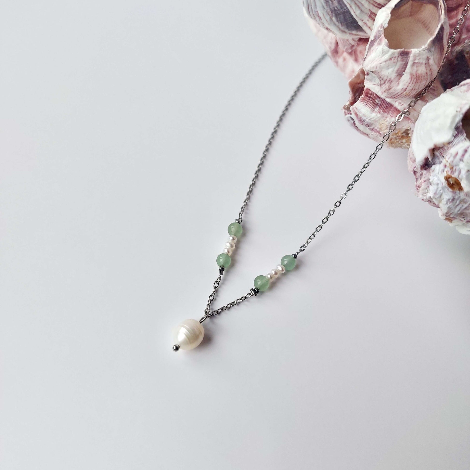Collier élégant avec chaine en acier inoxydable argenté paré de perles d'eau douce et perles d'aventurine verte.