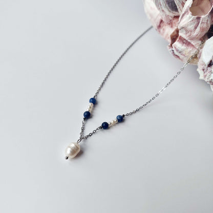 Collier élégant avec chaine en acier inoxydable argenté paré de perles d'eau douce et perles de sodalite bleue.