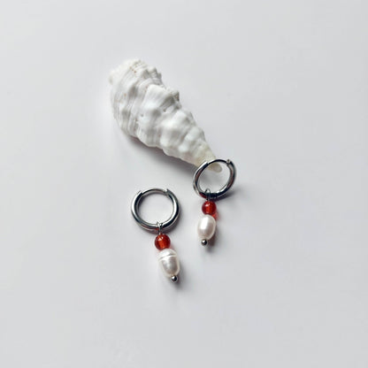 Boucles d'oreilles créoles en acier inoxydable argenté avec une pierre d'eau douce et une perle de cornaline. Design minimaliste et coloré.