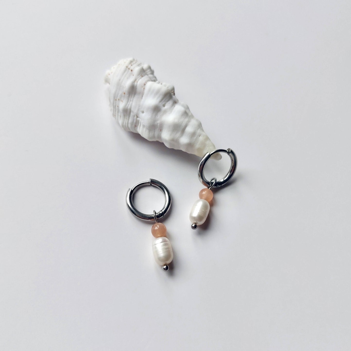 Boucles d'oreilles créoles en acier inoxydable argenté avec une pierre d'eau douce et une perle de pierre de soleil. Design minimaliste et coloré.