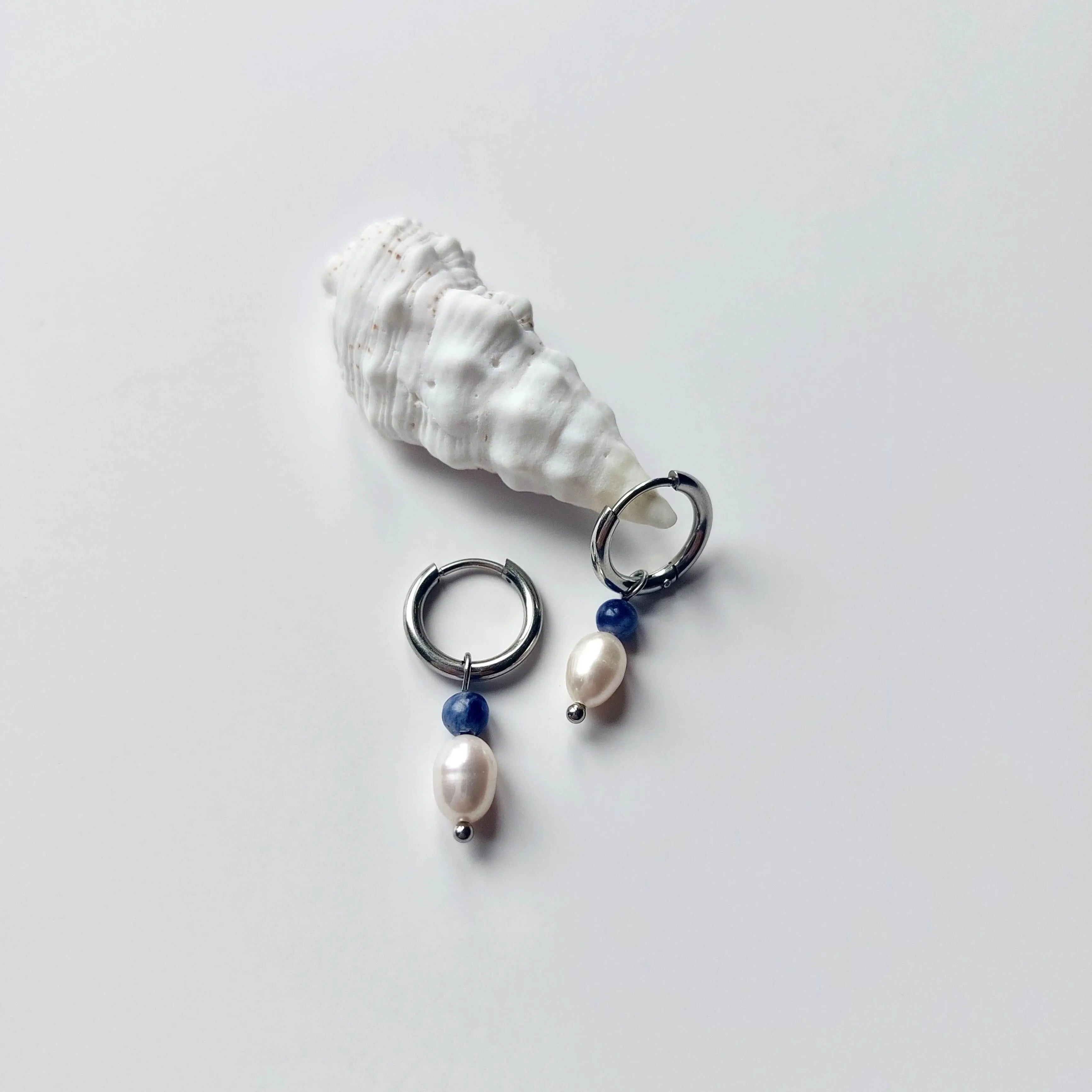 Boucles d'oreilles créoles en acier inoxydable argenté avec une pierre d'eau douce et une perle de sodalite. Design minimaliste et coloré.