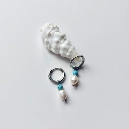 Boucles d'oreilles créoles en acier inoxydable argenté avec une pierre d'eau douce et une perle de turquoise. Design minimaliste et coloré.