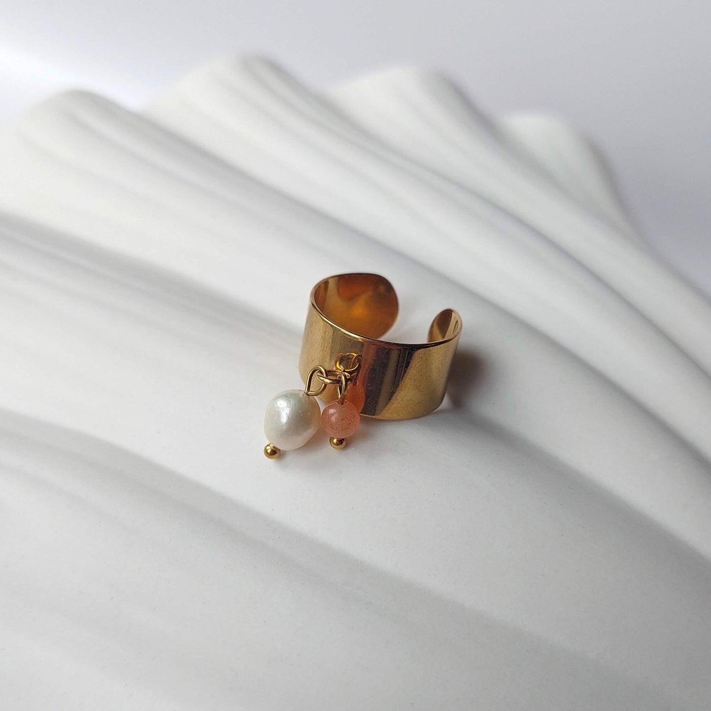 Bague en acier inoxydable à breloques de pierre de soleil et de perle d'eau douce.