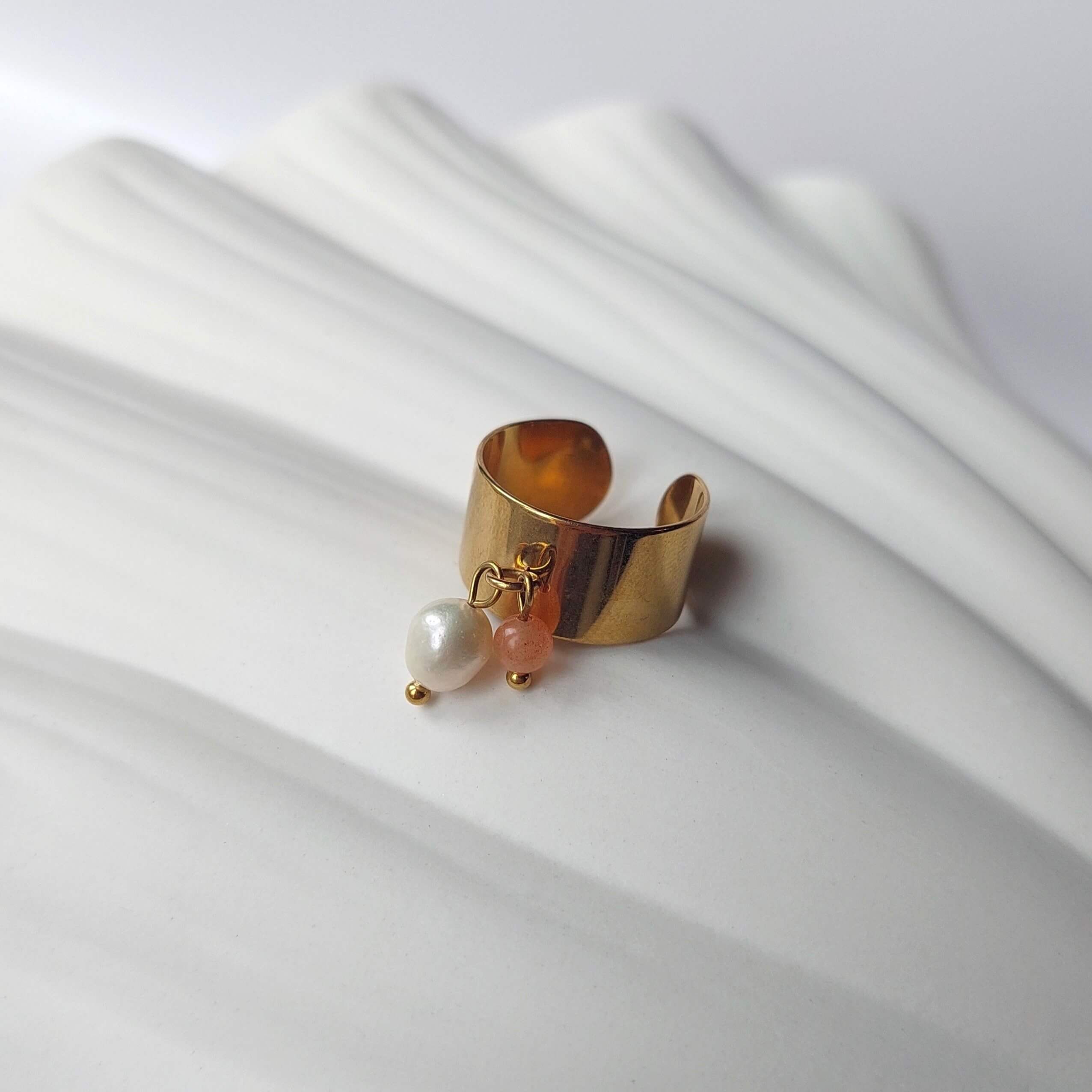 Bague en acier inoxydable à breloques de pierre de soleil et de perle d'eau douce.