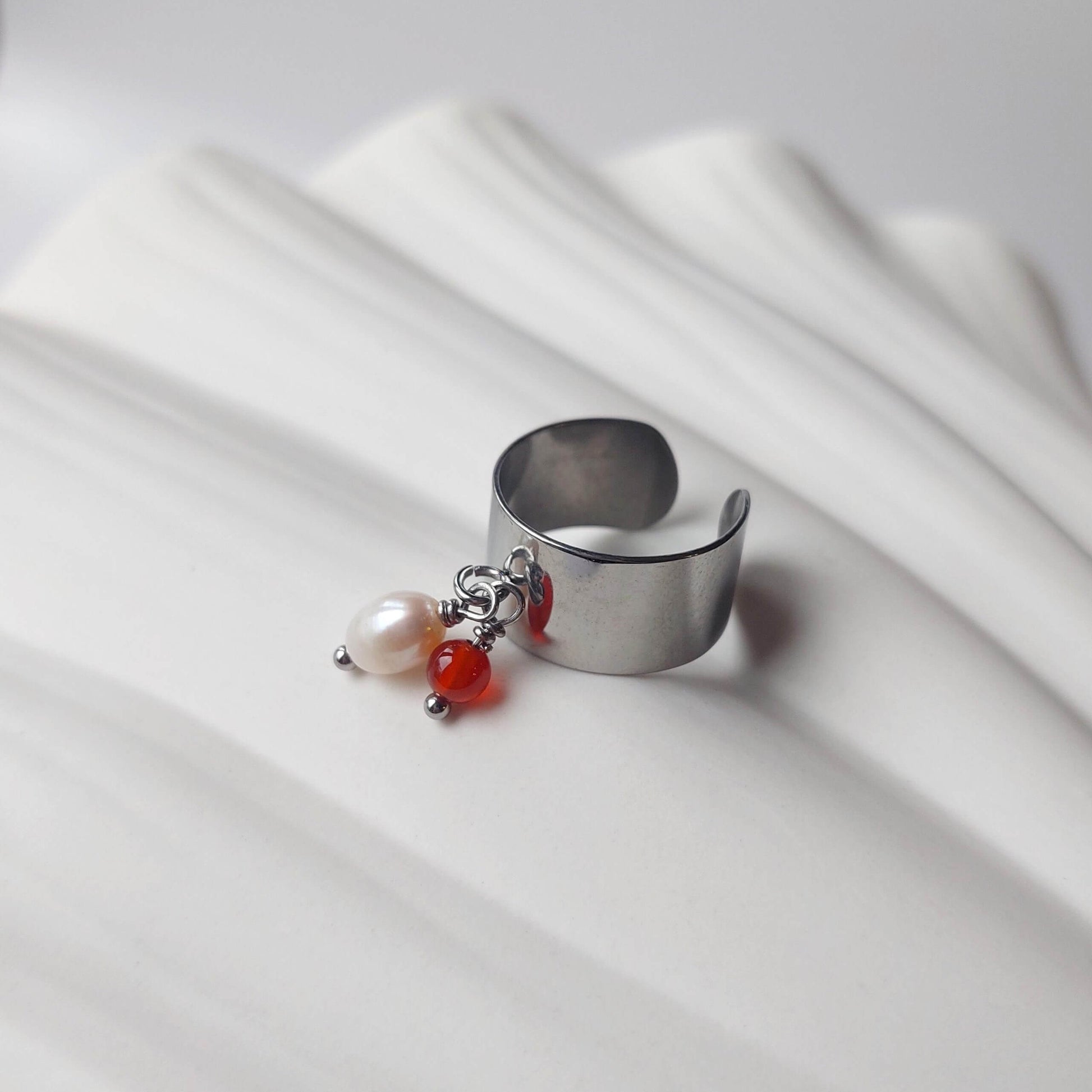 Bague en acier inoxydable argenté à breloques de cornaline et de perle d'eau douce.