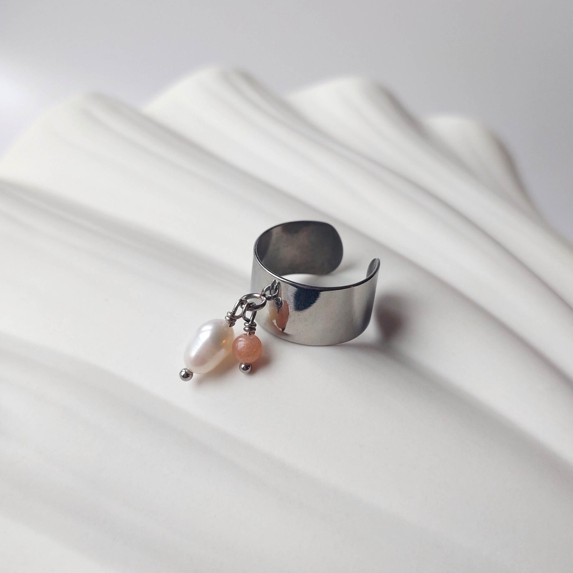 Bague en acier inoxydable argenté à breloques de pierre de soleil et de perle d'eau douce.